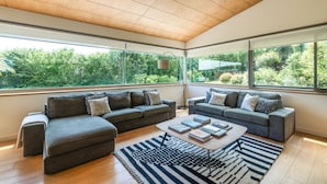 A modern living room with two grey sofas, a coffee table, and a black and white striped rug. - VILLA WITH LAND IN LLANES (La Pereda)