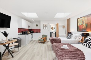 A modern hotel room with a bed, a sofa, a dining area, and a kitchen. - Unique Home • Annex • Pool Table • Virgin TV • Free Parking • Self-Check-In (Northampton)