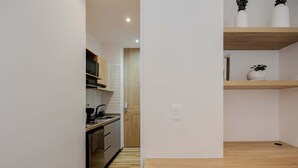 A modern kitchen with wooden cabinets, a built-in oven, and a coffee machine. - NOK Stylish 1-bedroom With Terrace on Calle 94 (Bogotá)