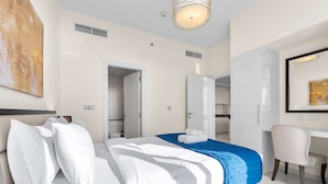 Una habitación de hotel moderna con una cama bien hecha, un escritorio y una silla.