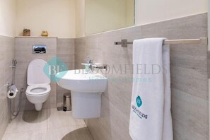 Ein modernes Badezimmer mit Toilette, Bidet und Waschbecken.
