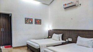 A hotel room with two beds, a wardrobe, and an air conditioning unit. - ICE APPLE RESORT (Nagaon)