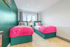 Un dormitorio con dos camas, una ventana y un radiador.