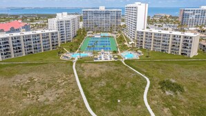 Ein Resort mit mehreren Hochhäusern, einem zentral gelegenen Tennisplatz und umliegenden Schwimmbecken.