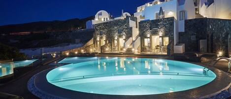 En sÀsongsöppen utomhuspool, parasoller och solstolar