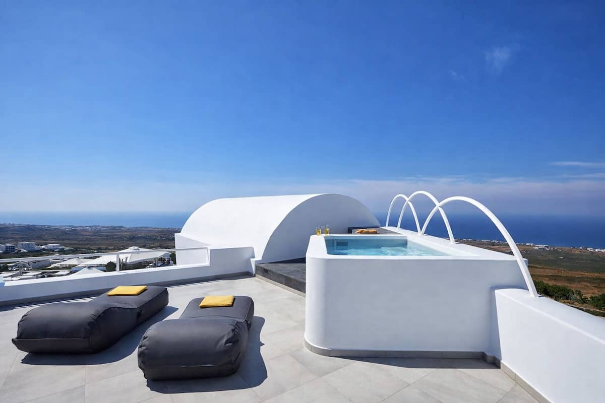 Eine Dachterrasse mit Pool, Liegestühlen und Blick auf die Küstenlinie.