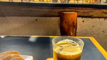 A table with a glass of iced coffee and two slices of bread on a tray.