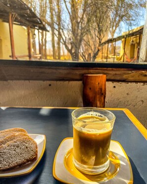 A table with a glass of iced coffee and two slices of bread on a tray. - Casa Vacaional (Rodeo)