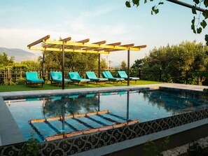 A swimming pool with blue lounge chairs and a pergola. - Filippos Traditional Villa - Garden Pool Gem (Finiq)