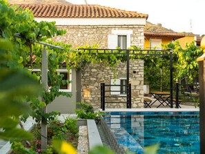 A stone house with a tiled roof, a swimming pool, and a garden with vines. - Filippos Traditional Villa - Garden Pool Gem (Finiq)