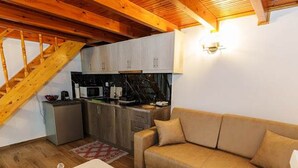 Ein gemütlicher Wohnbereich mit Küche, Sofa und Esstisch.
