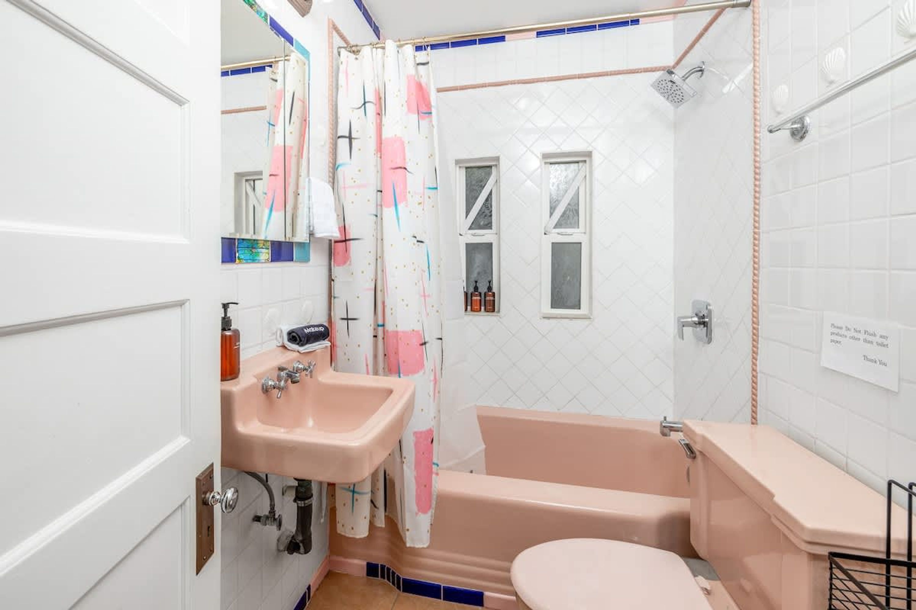 Ein Badezimmer mit Waschbecken, Toilette und Badewanne. Es gibt ein Fenster und eine Dusche.