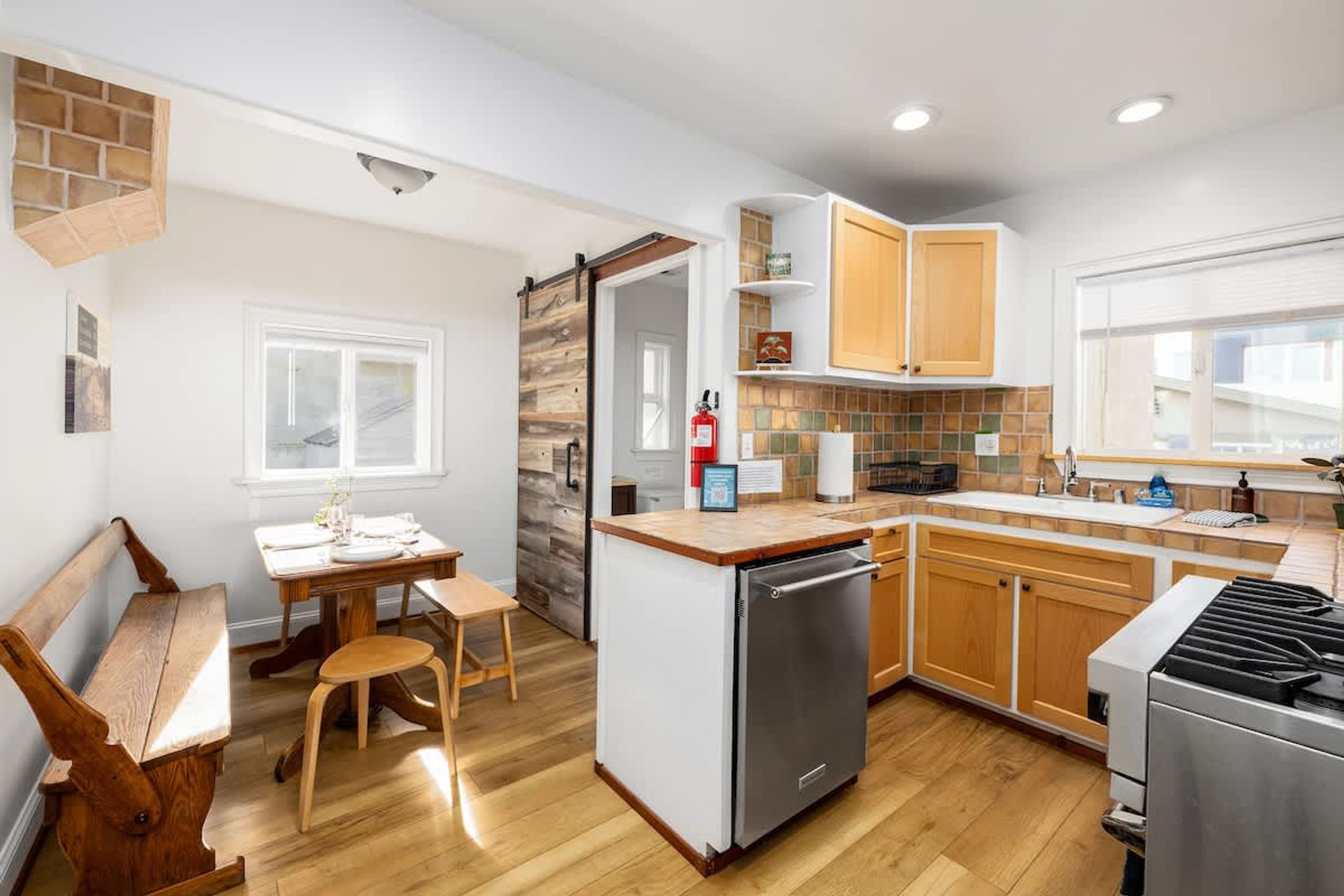 A modern kitchen with wooden cabinets, a built-in dishwasher, and a gas stove.