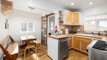 A modern kitchen with wooden cabinets, a built-in dishwasher, and a gas stove.