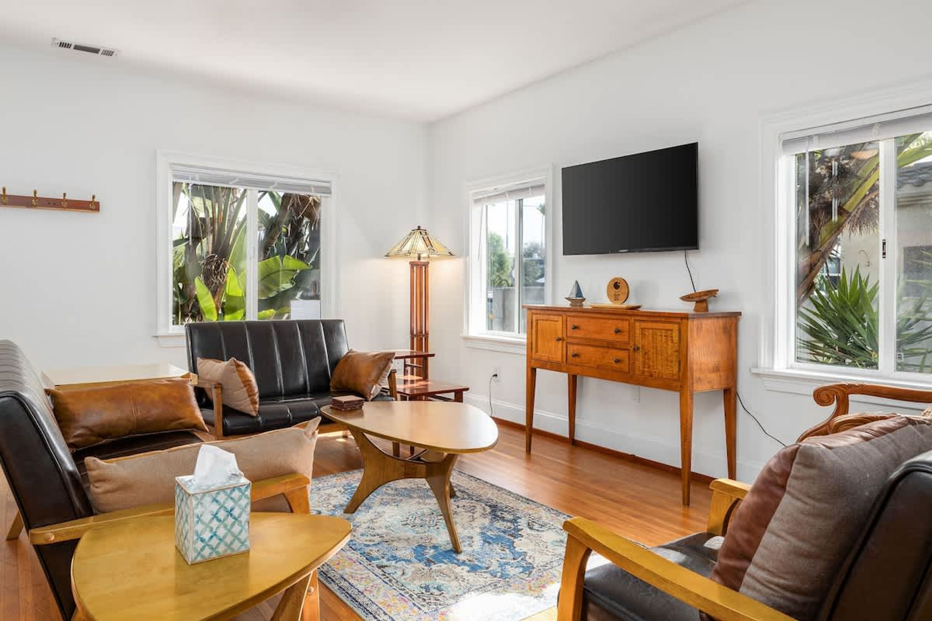 A living room with a sofa, coffee table, lamp, TV, and wooden cabinet.