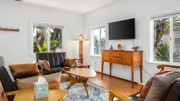 A living room with a sofa, coffee table, lamp, TV, and wooden cabinet.