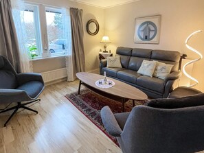 A modern living room with a leather sofa, two armchairs, a coffee table, and a lamp. - 4 Star Holiday Home in Bergkvara (Bergkvara)