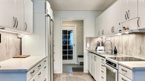 A modern kitchen with white cabinets, a built-in oven, and a countertop with a coffee maker. - 4 Star Holiday Home in Bergkvara (Bergkvara)
