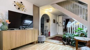 A modern living room with a wooden cabinet, flat-screen TV, and a staircase leading to an upper level. - 4 Star Holiday Home in Bergkvara (Bergkvara)