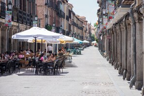 A street lined with outdoor cafes, tables, and chairs, with buildings on either side. - Cervantes Balcony (Alcalá de Henares)