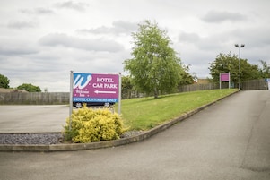 A sign for a hotel car park with directions for hotel customers.