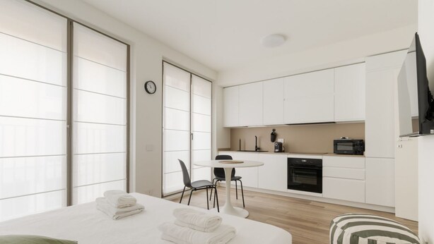 A modern hotel room with a bed, a small dining table, a kitchenette, and a TV. - GuestHost - Modern 40 mq studio apartment located on the first floor of a residential complex with a lift.The property is located within the Moscova district, a well-known central area of ​​Milan, the hub of Milanese nightlife and aperitifs.The area  (Milan)