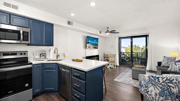 A modern kitchen with blue cabinets, a built-in microwave, and a large island. - Close to the Boardwalk, Jolly Roger Amusement Park and All the OC Fun! (Ocean City)
