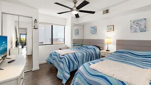 A bedroom with two beds, a ceiling fan, a window, and artwork on the walls. - Close to the Boardwalk, Jolly Roger Amusement Park and All the OC Fun! (Ocean City)