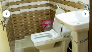 Un baño pequeño con inodoro, lavabo y ducha.