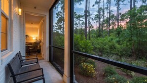 A porch with a view of a forest and a building with a white exterior. - 2BR | 2BA Close to Beach, Luxury Amenities + Free Tix: Dolphin Cruise & More! (Santa Rosa Beach)