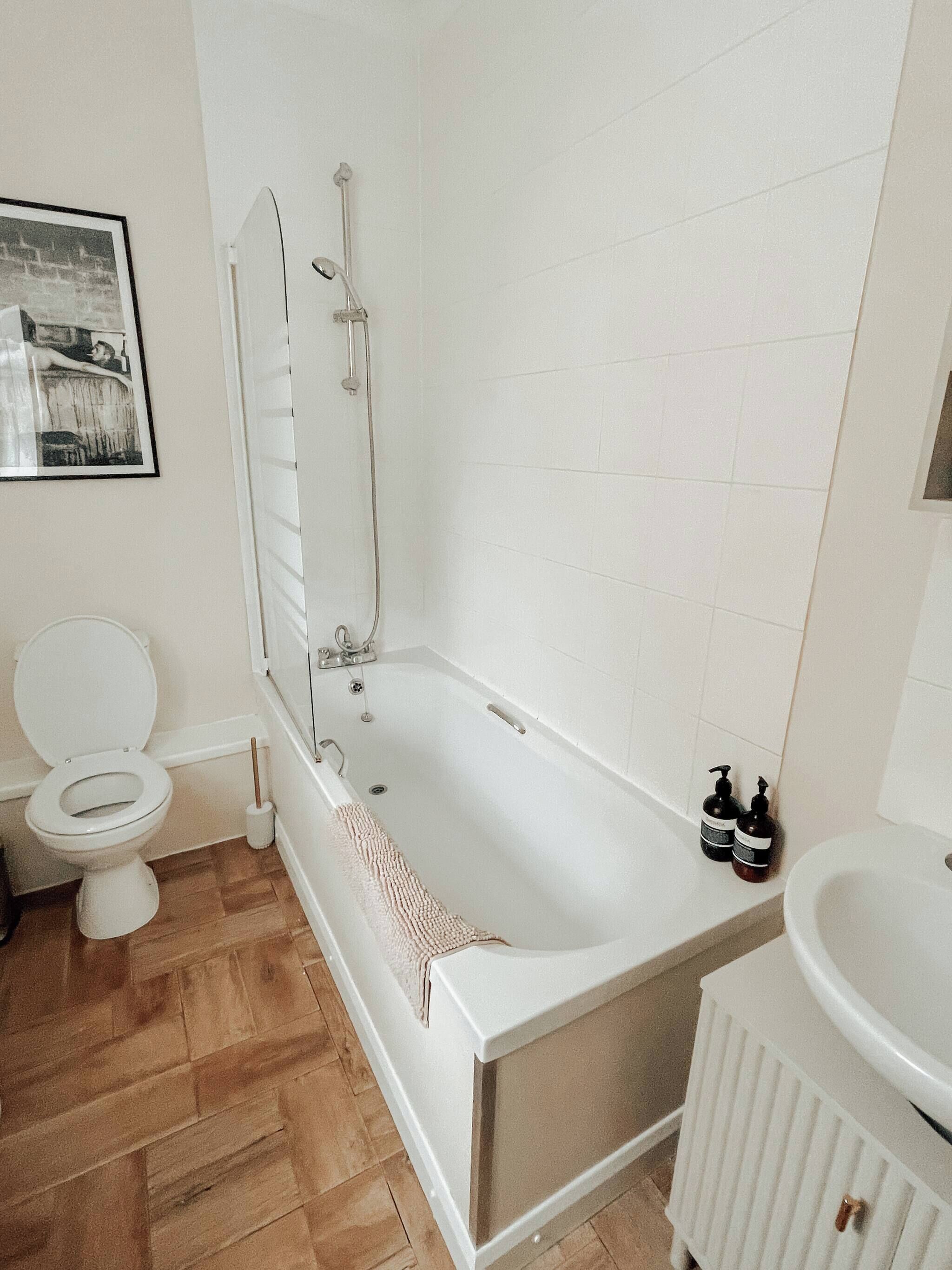 A bathroom with a bathtub, toilet, and sink.