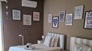 A hotel room with two beds, a wall-mounted air conditioner, and several motivational posters. - Beautiful apartment recently renovated and complete with everything (Roma)