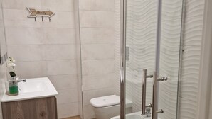 A modern bathroom with a glass shower enclosure, a wooden vanity, a white sink, and a toilet. - Beautiful apartment recently renovated and complete with everything (Roma)
