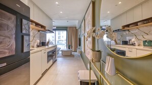 Una cucina moderna con isola centrale, elettrodomestici integrati e vista all'esterno.