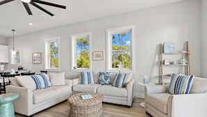 A living room with two sofas, a coffee table, and a bookshelf. - Pet Friendly Beach House - Bella View (Port St. Joe)