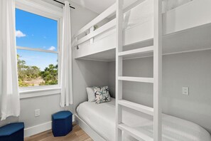 Dormitorio con literas y vista a árboles y cielo.