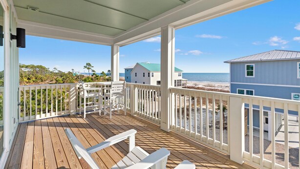 A wooden deck with white railings and a view of the beach and ocean. - Pet Friendly Beach House - Bella View (Port St. Joe)