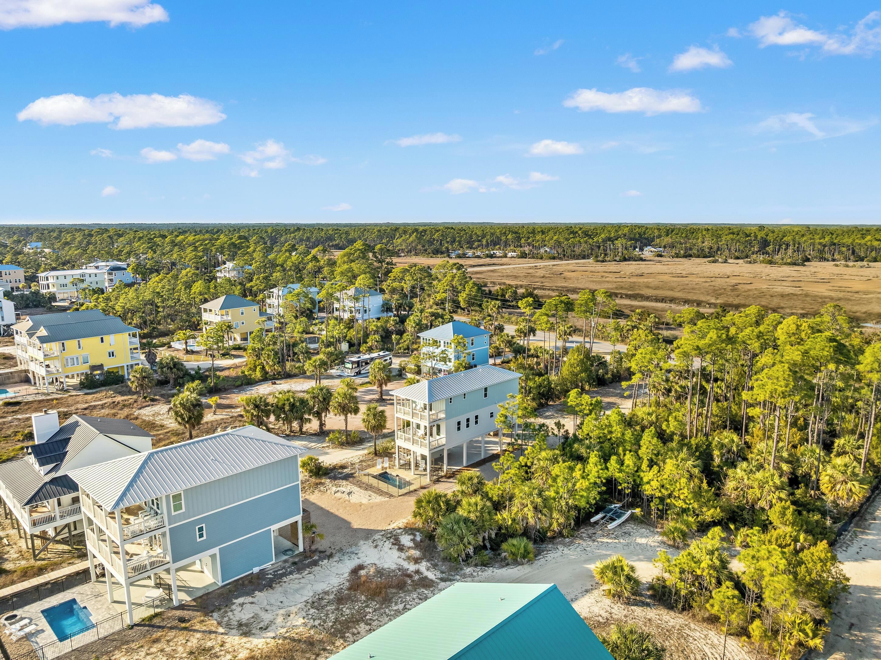 A coastal residential area with multiple two-story houses, a swimming pool, and a beach.