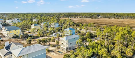 A coastal residential area with multiple two-story houses, a swimming pool, and a beach.
