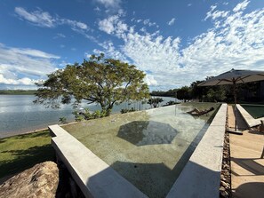 Una piscina al aire libre, sillones reclinables de piscina