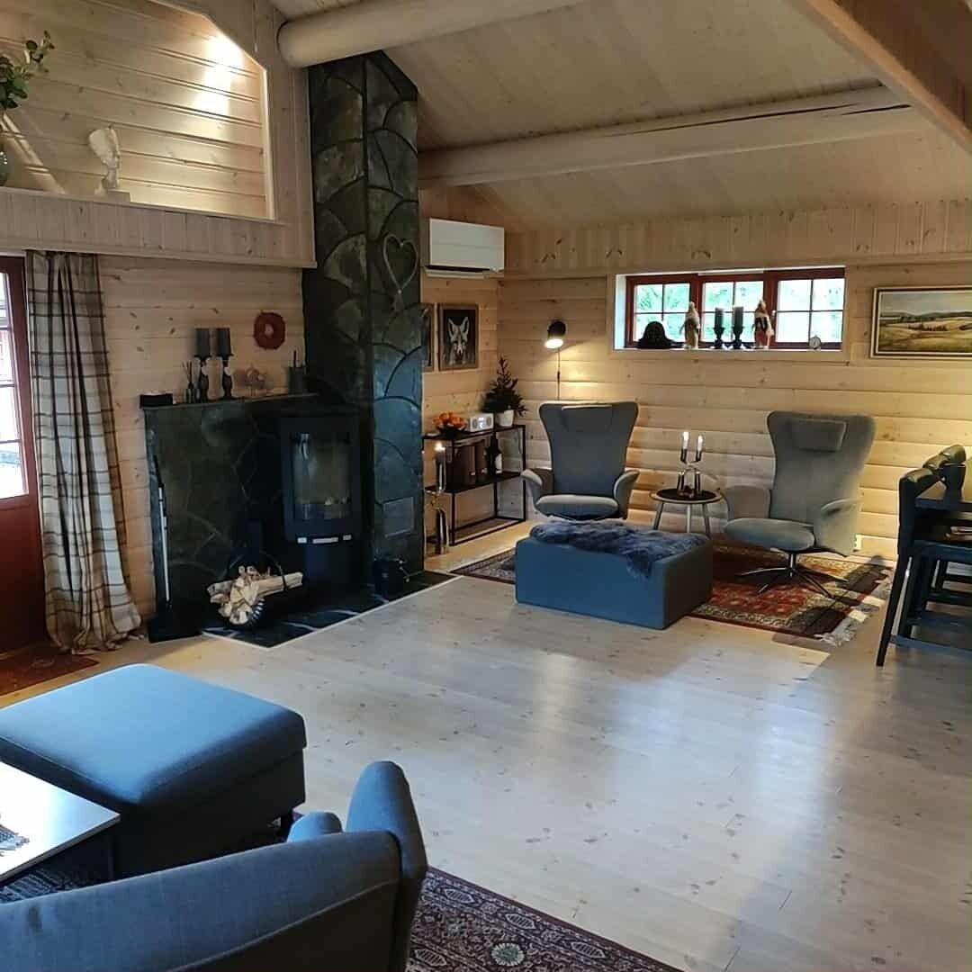 Een knusse woonkamer met een open haard, comfortabele zitplaatsen en een stenen accentmuur.