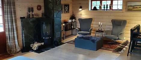 Een knusse woonkamer met een open haard, comfortabele zitplaatsen en een stenen accentmuur.