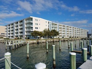 A multi-story hotel with balconies, a waterfront view, and a dock area. - Thunder Island 13a 2 Bedroom Condo (Ocean City)