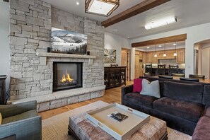 Ein Wohnzimmer mit Kamin aus Stein, einer Couch und einem Couchtisch.