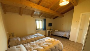 Une chambre avec deux lits, un bureau et une chaise.