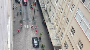 An aerial view of a street with buildings, parked cars, and pedestrians. - kitnet petropolis (Petrópolis)