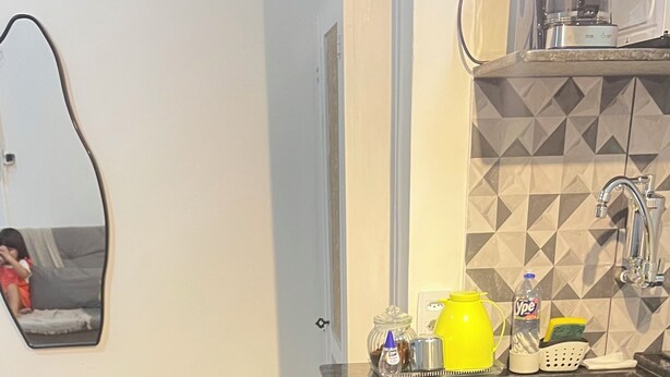 A modern kitchen with two black bar stools, a coffee machine, and a tiled backsplash. - kitnet petropolis (Petrópolis)