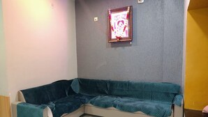 Habitación de esquina con sofá color turquesa, un cuadro en la pared y un interruptor de luz.