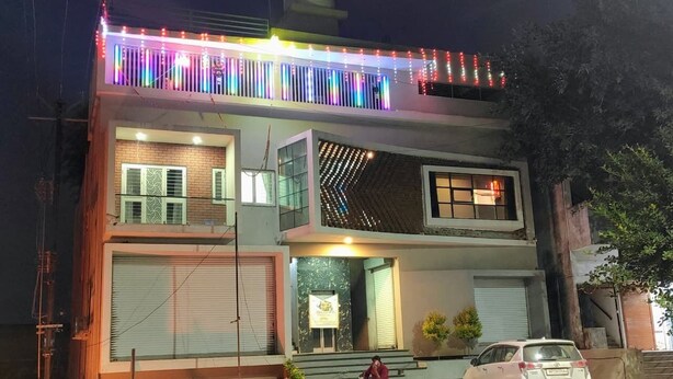Un edificio de dos pisos con un balcón decorado con luces de colores.