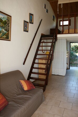 A room with a wooden staircase, a bed with a pillow, and a painting on the wall. - Waterfront paradise (Vico)